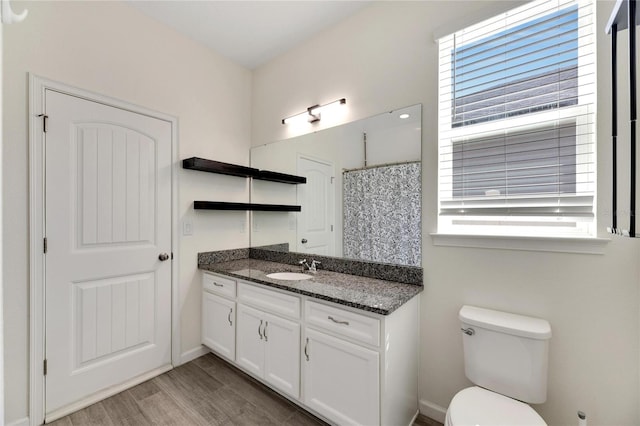 bathroom with toilet, hardwood / wood-style flooring, and vanity