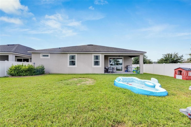 rear view of house featuring a yard and a patio