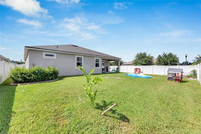 rear view of property with a yard and a patio