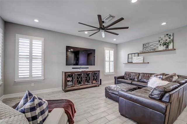 living room featuring ceiling fan, a wealth of natural light, and light hardwood / wood-style flooring