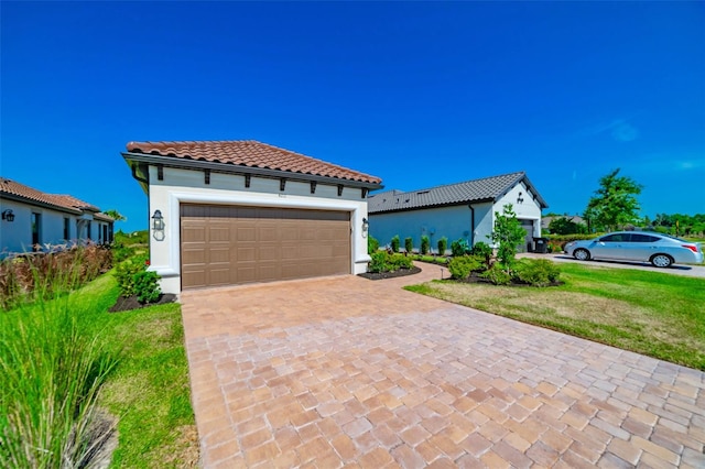 mediterranean / spanish-style house featuring a garage and a front lawn