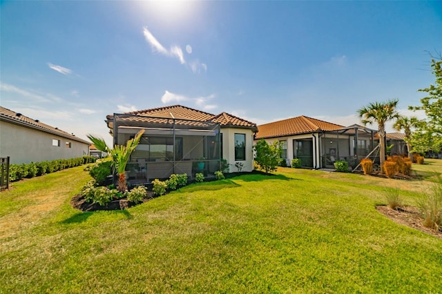 back of property with a lanai and a lawn