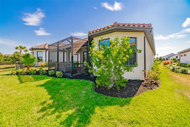 back of property with a lawn and a lanai