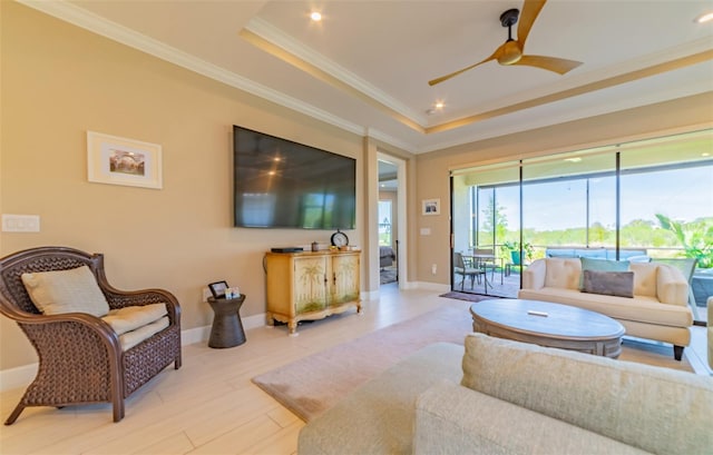 living room with crown molding, a raised ceiling, hardwood / wood-style floors, and ceiling fan