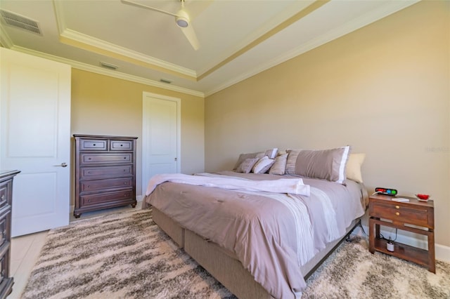 bedroom featuring ceiling fan, a raised ceiling, and crown molding