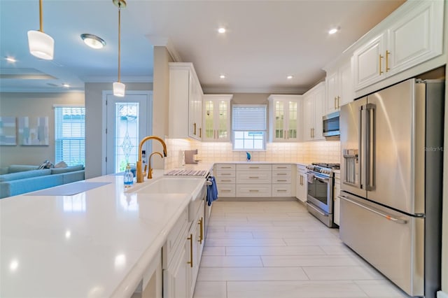 kitchen with crown molding, hanging light fixtures, stainless steel appliances, decorative backsplash, and white cabinets