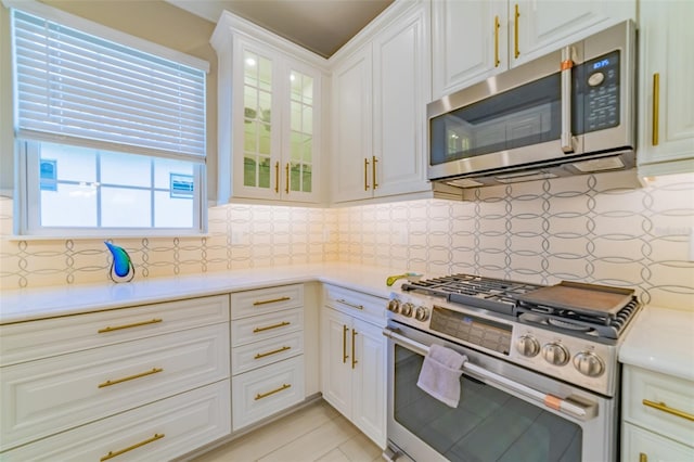 kitchen with white cabinetry, stainless steel appliances, and tasteful backsplash