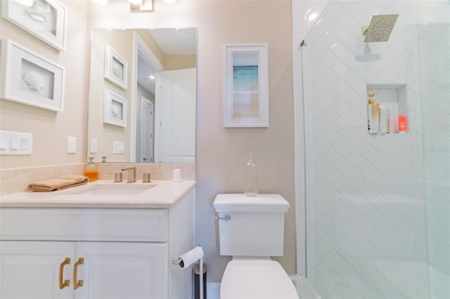 bathroom with vanity, toilet, and a tile shower