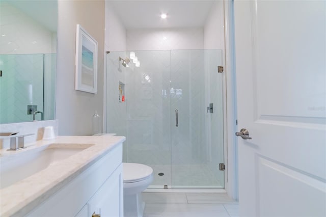 bathroom with tile patterned floors, toilet, a shower with door, and vanity