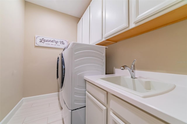 laundry area with cabinets, washer and dryer, and sink