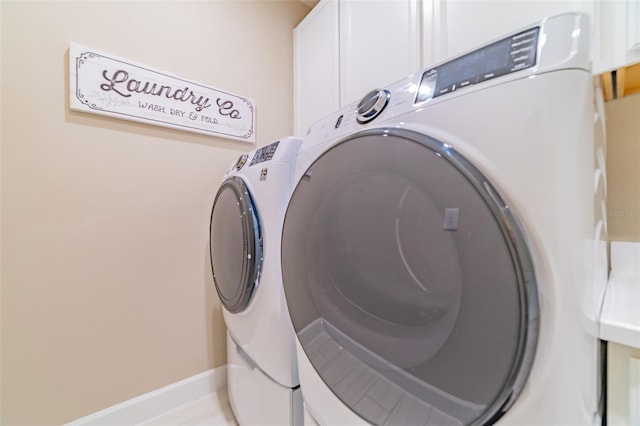 laundry area featuring cabinets and washer and clothes dryer