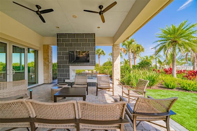 view of patio featuring an outdoor living space with a fireplace and ceiling fan