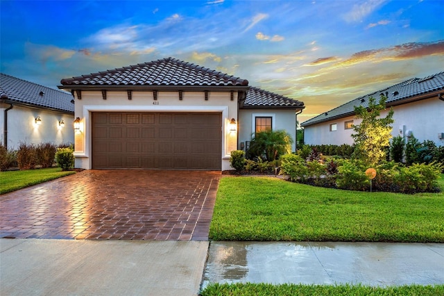 mediterranean / spanish house with a garage and a yard