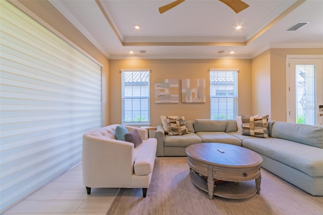 living room with crown molding, a tray ceiling, and ceiling fan