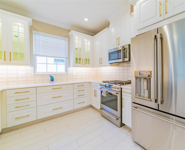 kitchen with light wood-type flooring, appliances with stainless steel finishes, backsplash, and white cabinetry