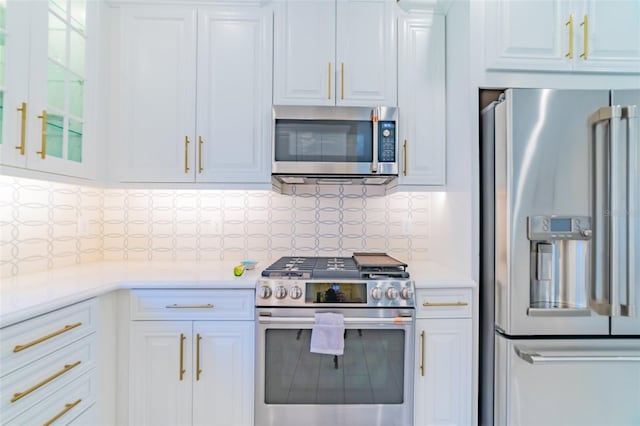 kitchen with white cabinets, stainless steel appliances, and decorative backsplash