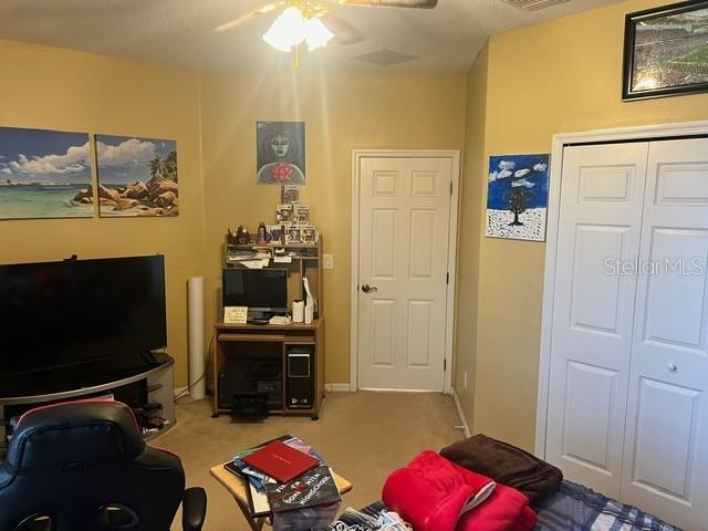 carpeted living room featuring ceiling fan