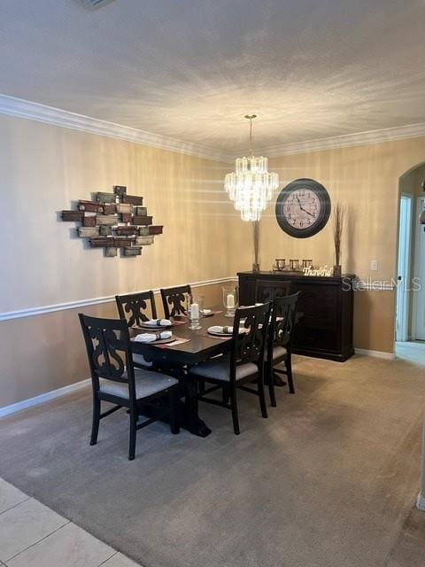 dining area with ornamental molding, tile patterned floors, and a notable chandelier