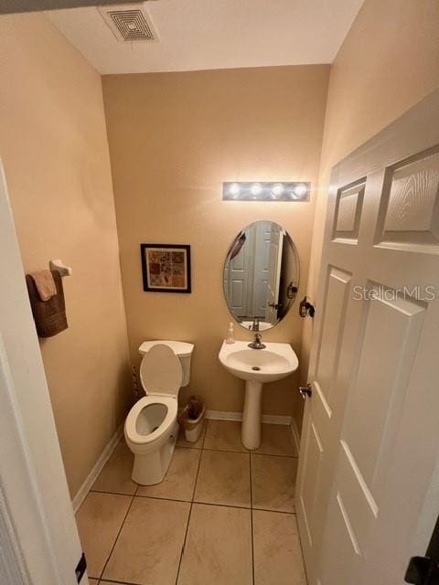 bathroom featuring toilet and tile patterned flooring