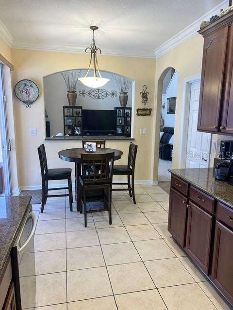 tiled dining room featuring ornamental molding