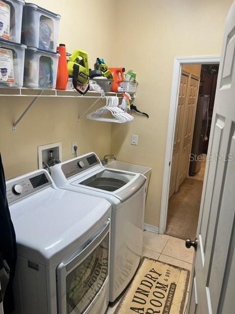 laundry area with washing machine and clothes dryer and light carpet