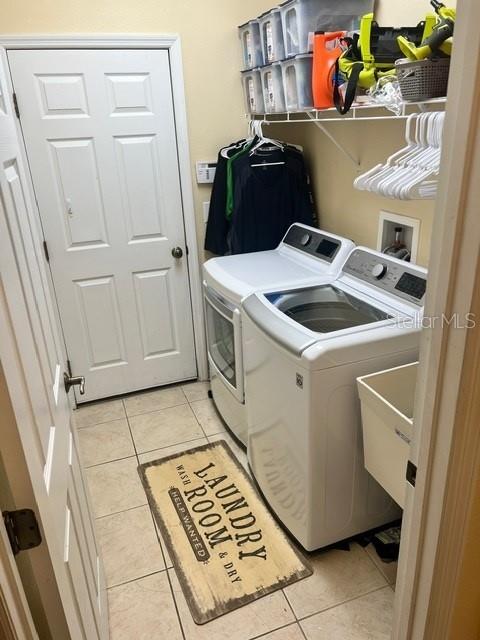 laundry area featuring light tile patterned floors and washer and dryer