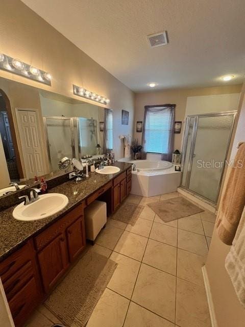 bathroom with tile patterned flooring, independent shower and bath, a textured ceiling, and vanity