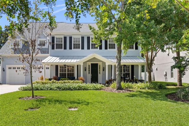 view of front of house with a garage, a front lawn, and covered porch