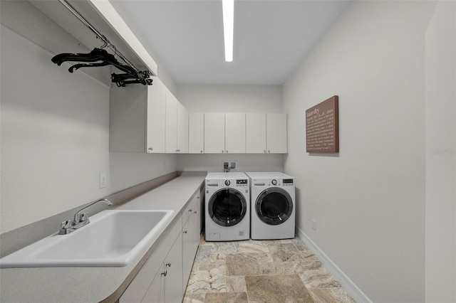 clothes washing area with washer and dryer, sink, and cabinets