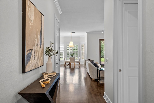 hall with dark wood-type flooring and ornamental molding