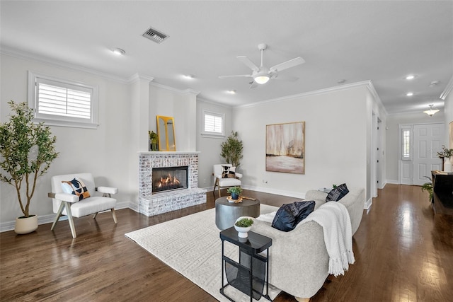 living room with ornamental molding, a brick fireplace, ceiling fan, and dark hardwood / wood-style flooring