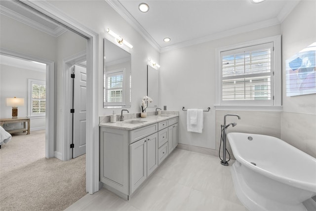 bathroom with vanity, crown molding, and a tub to relax in