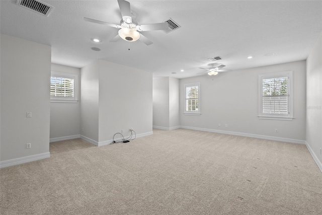 empty room featuring ceiling fan and light colored carpet