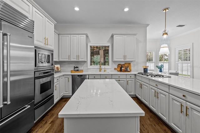 kitchen with tasteful backsplash, built in appliances, and a center island