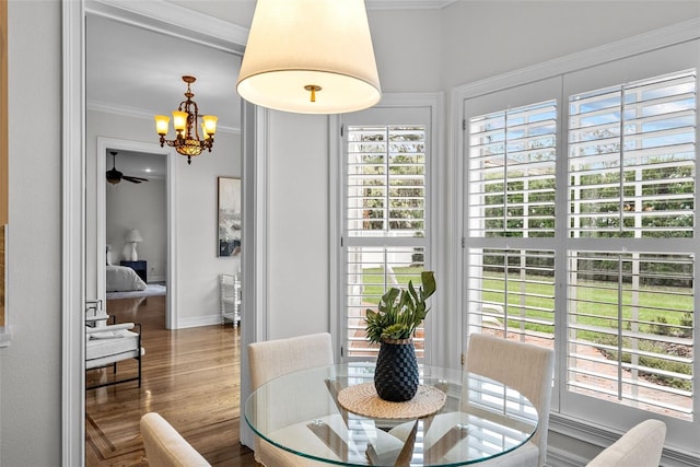 dining space featuring crown molding, hardwood / wood-style floors, and an inviting chandelier