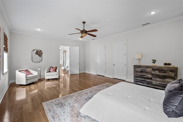 bedroom featuring hardwood / wood-style floors, ornamental molding, and ceiling fan