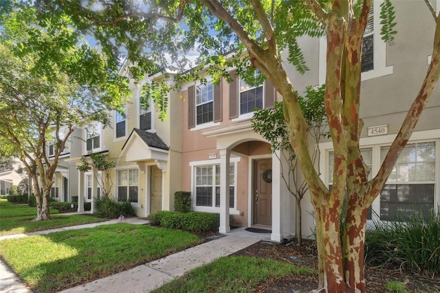 view of property featuring a residential view, a front lawn, and stucco siding