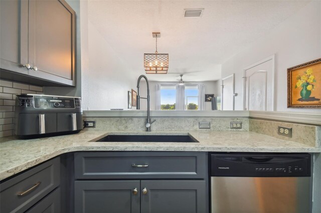 kitchen featuring sink, stainless steel dishwasher, decorative light fixtures, backsplash, and gray cabinets