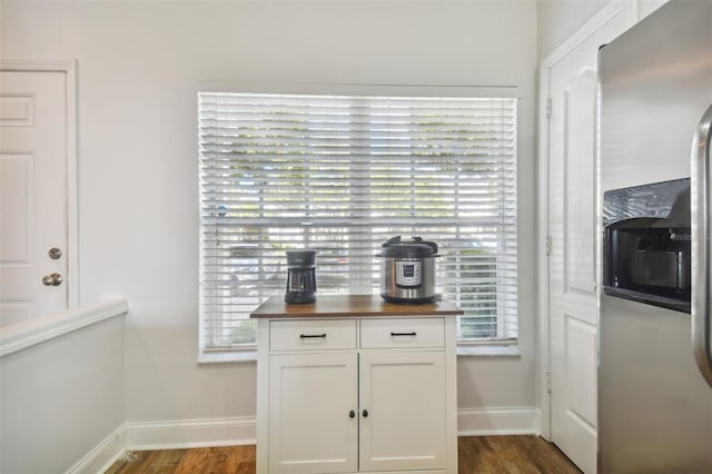 interior space with white cabinets, stainless steel refrigerator with ice dispenser, butcher block counters, and dark wood-type flooring