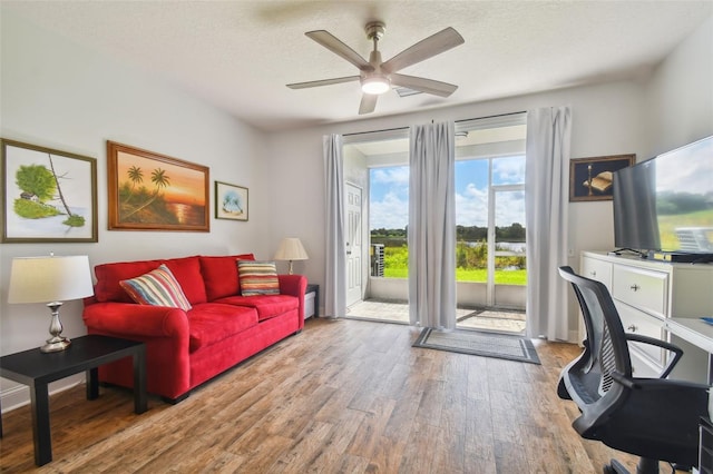 interior space featuring ceiling fan, hardwood / wood-style flooring, and a textured ceiling