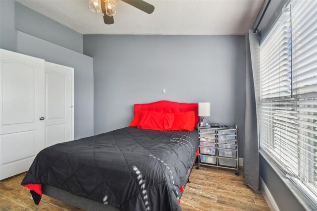 bedroom with wood-type flooring, lofted ceiling, and ceiling fan