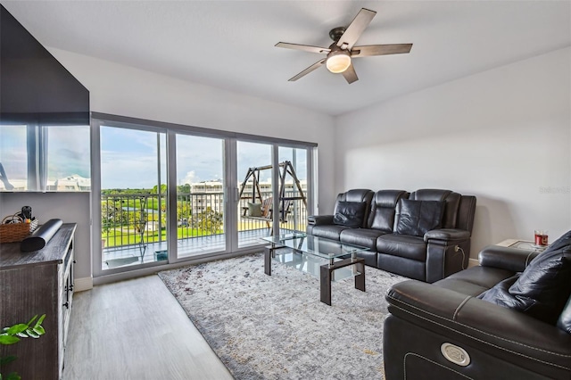 living room featuring ceiling fan and light hardwood / wood-style floors