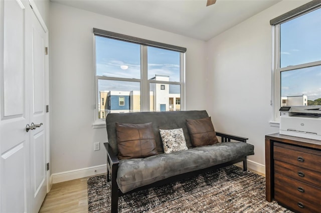 living area with ceiling fan and light wood-type flooring