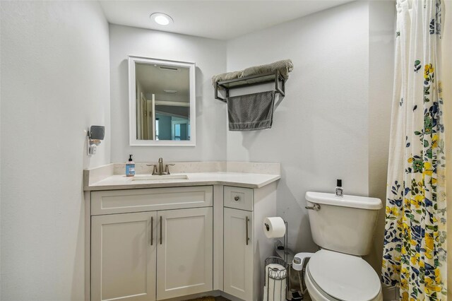 bathroom featuring curtained shower, vanity, and toilet