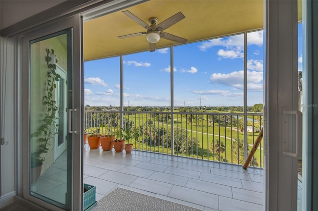 unfurnished sunroom featuring ceiling fan