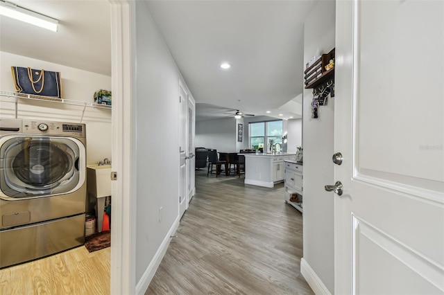 laundry area featuring washer / clothes dryer, ceiling fan, and light hardwood / wood-style floors