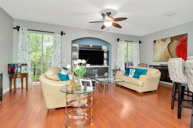 living room featuring wood-type flooring and ceiling fan