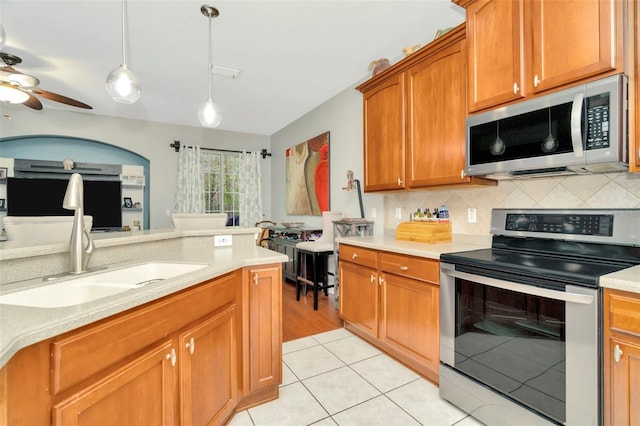 kitchen with pendant lighting, appliances with stainless steel finishes, sink, ceiling fan, and light tile patterned flooring