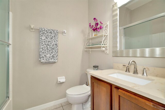 bathroom featuring a shower with door, vanity, toilet, and tile patterned floors