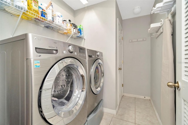 clothes washing area with separate washer and dryer and light tile patterned floors